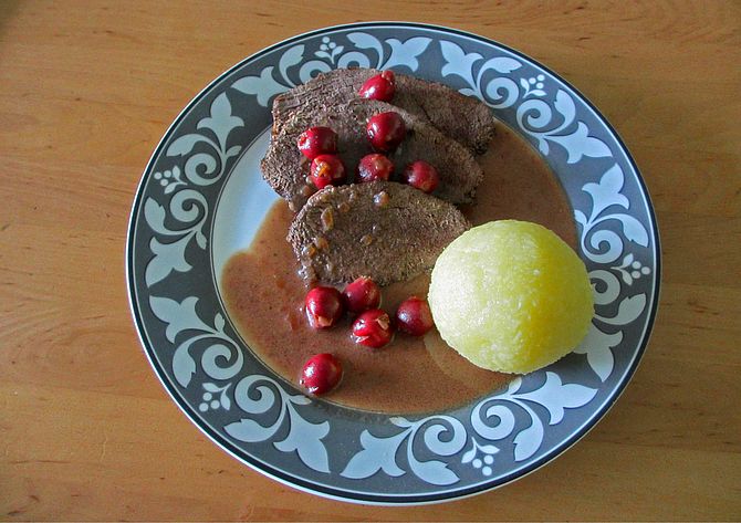 Braten vom Hirsch mit Soße von Sauerkirschen und Knödeln