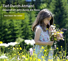 Mädchen riecht an Blumen