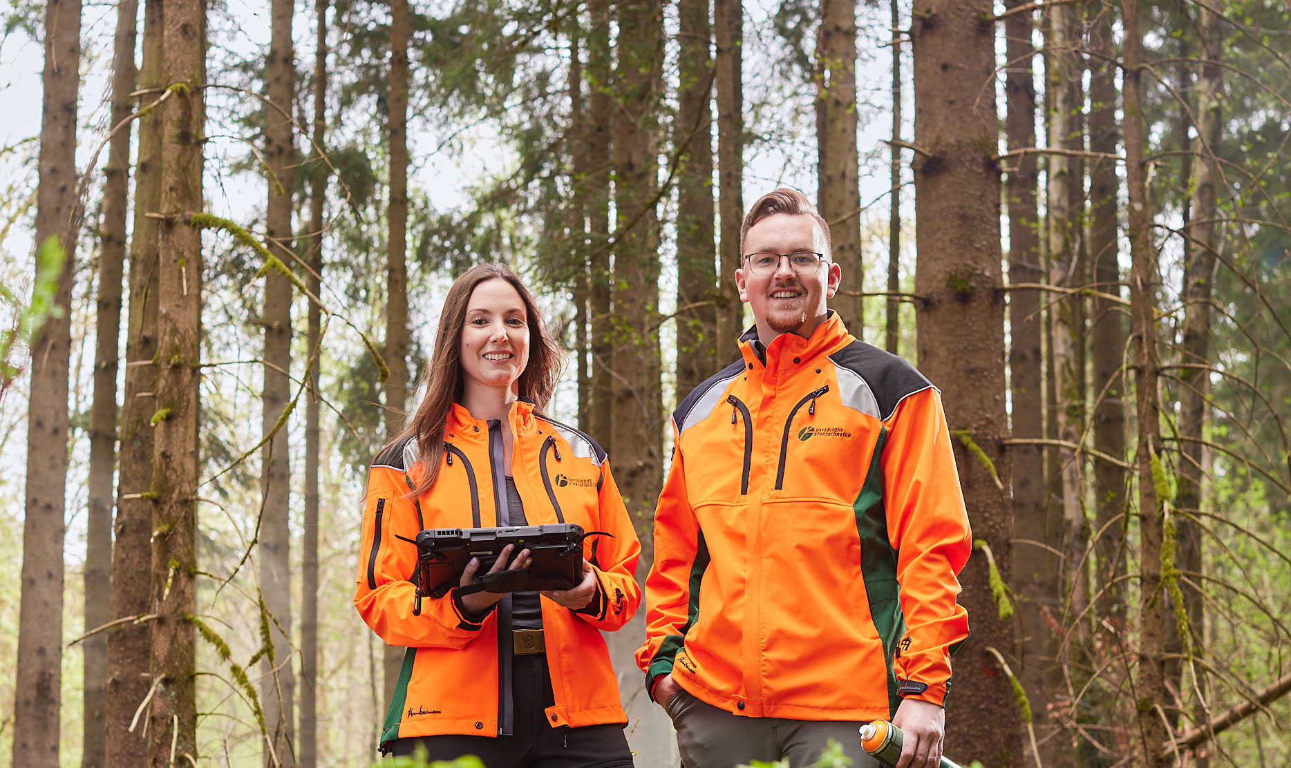 Eine Frau und ein Mann in BaySF Kleidung im Wald