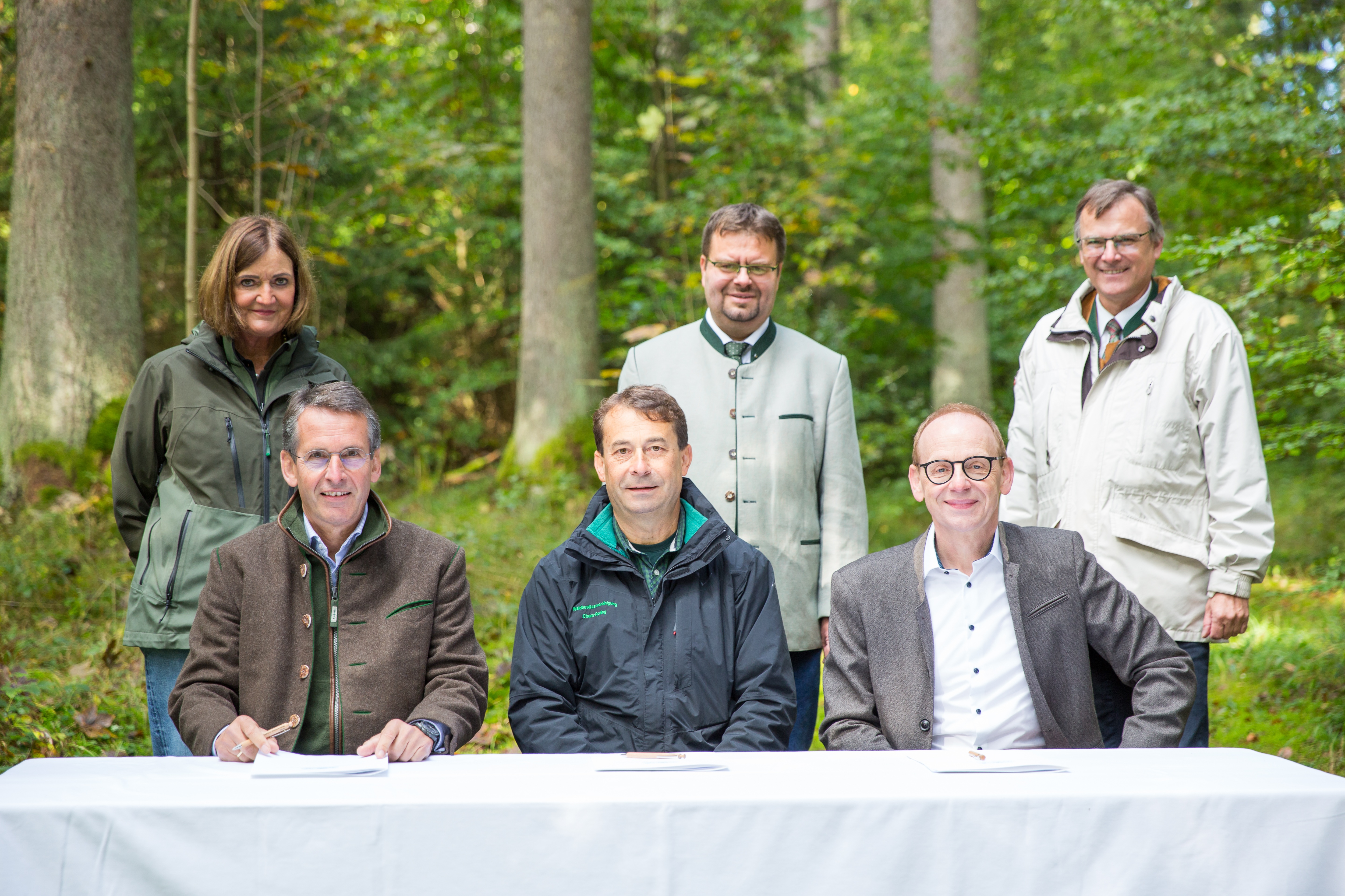 Personen unterzeichnen die Schutzwaldvereinbarung