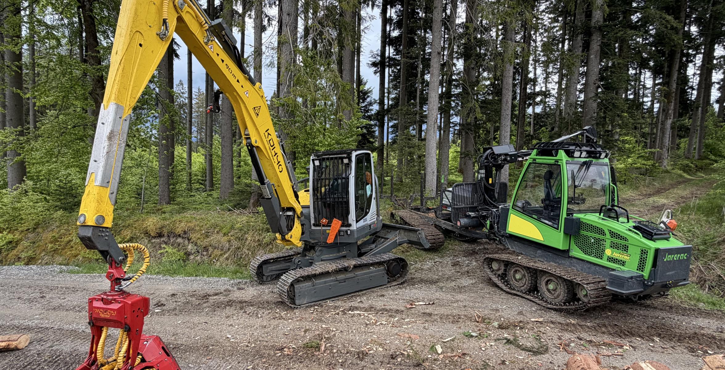 Ein Harvester und ein Rückezug bei der Holzernte im Wald.