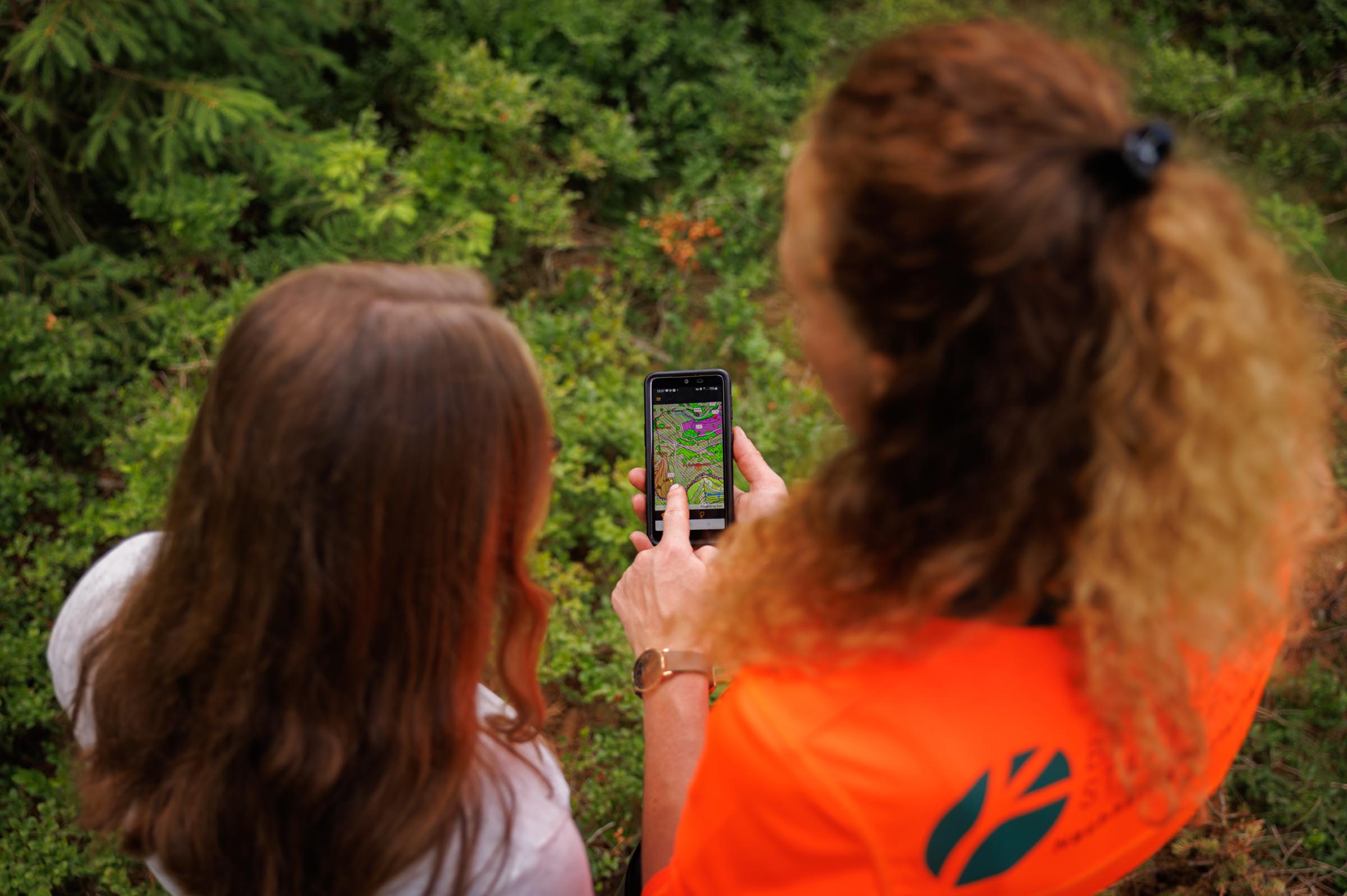 Zwei Frauen nutzen die Borkenkäfer-App der Bayerischen Staatsforsten im Wald – digitale Schädlingsbekämpfung per Smartphone in Echtzeit.