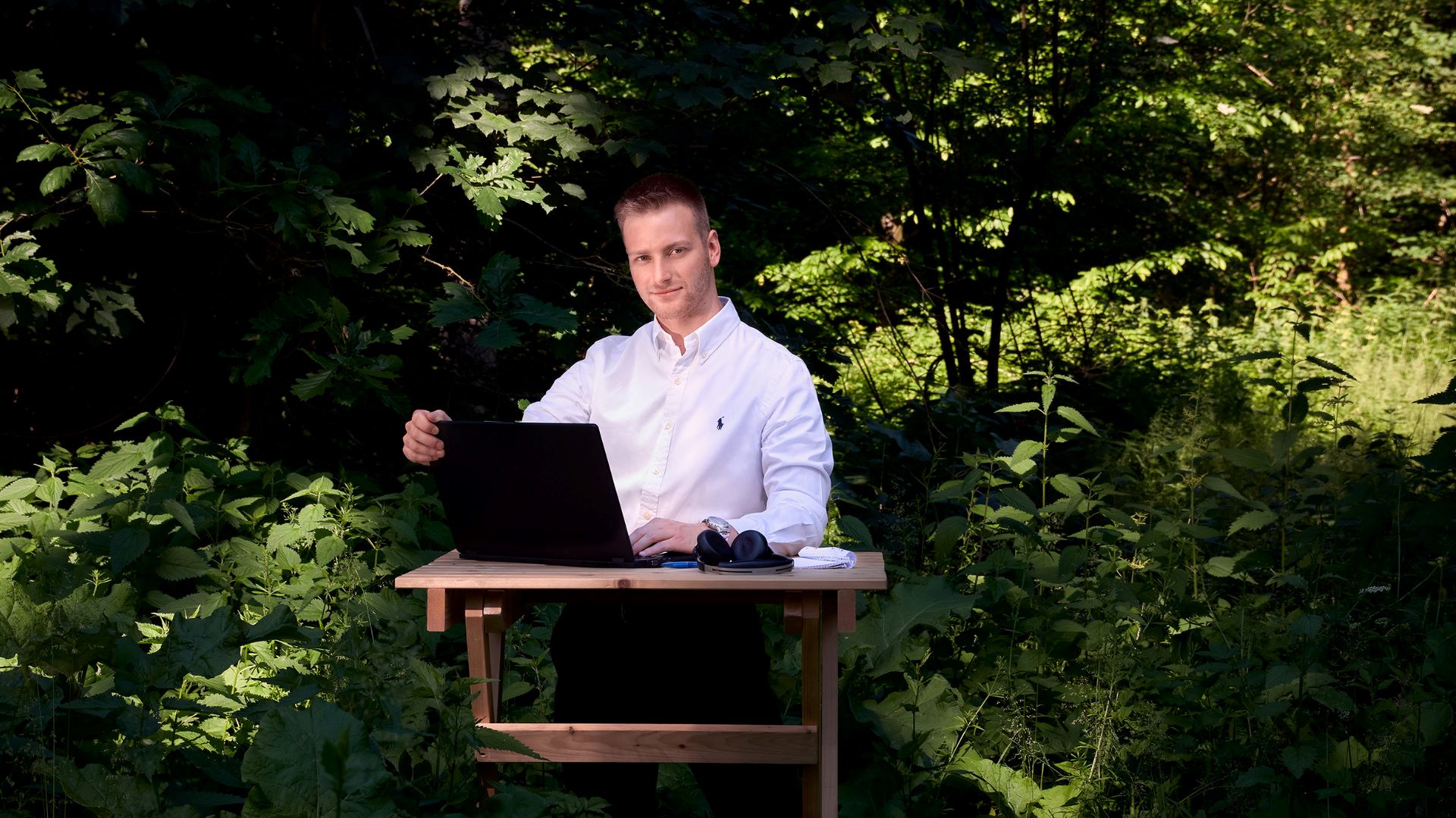 IT Fachmann sitzt am Schreibtisch im Wald
