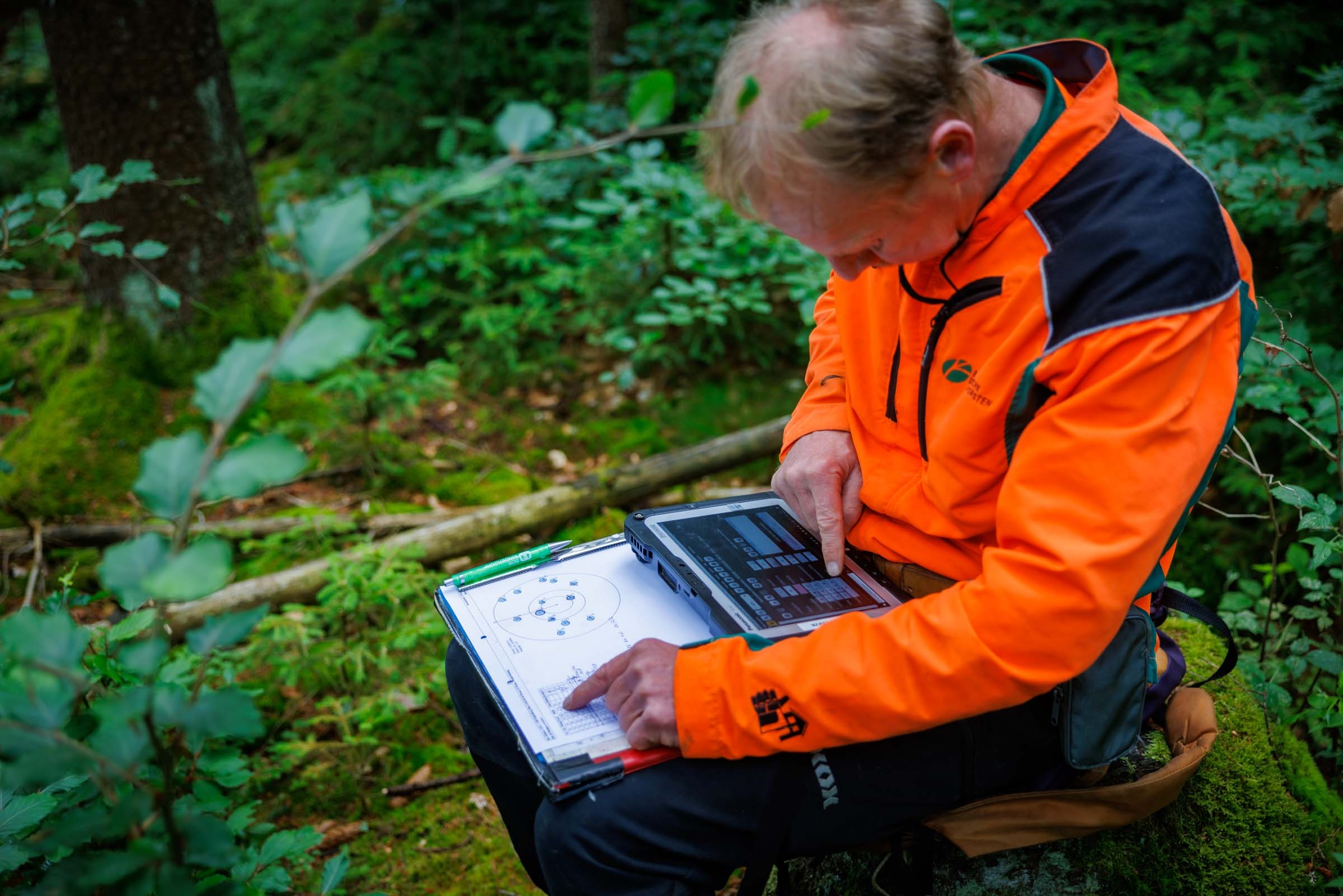 Ein Forsteinrichter gibt die Daten auf seinem Tablet ein.