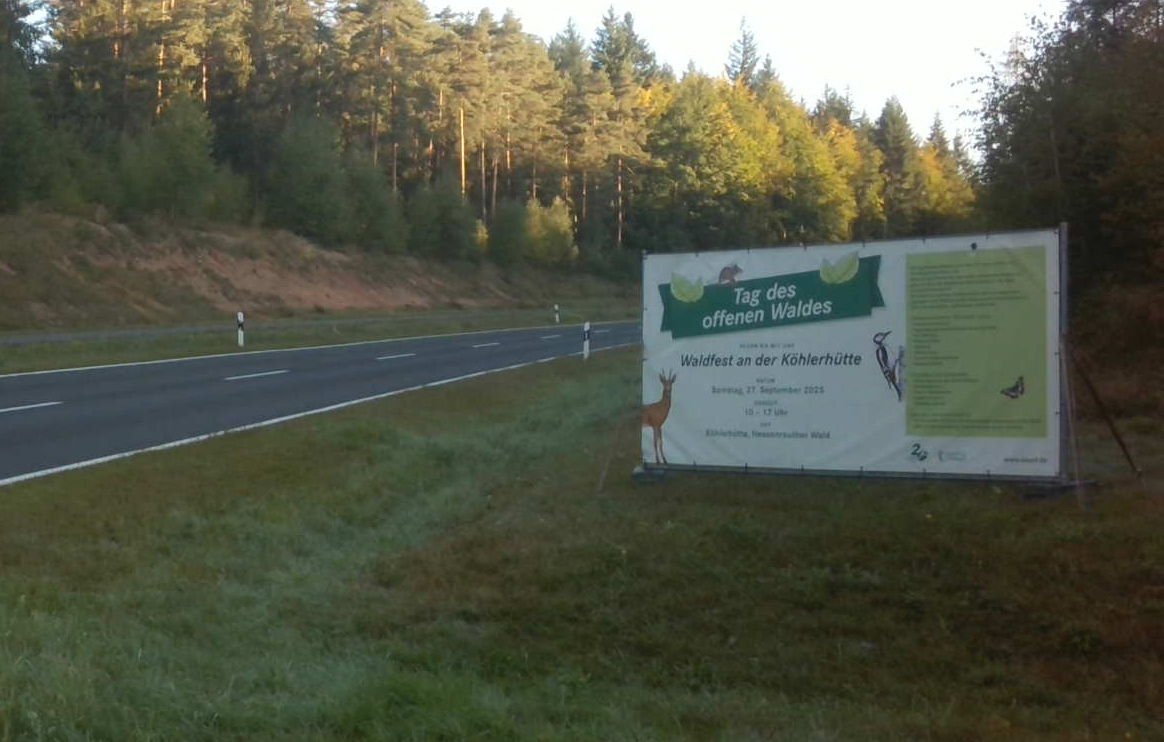 Schild an der Straße wirbt für das Waldfest