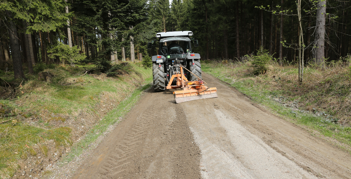 Maschine für Wegepflege zieht Material glatt auf dem Weg