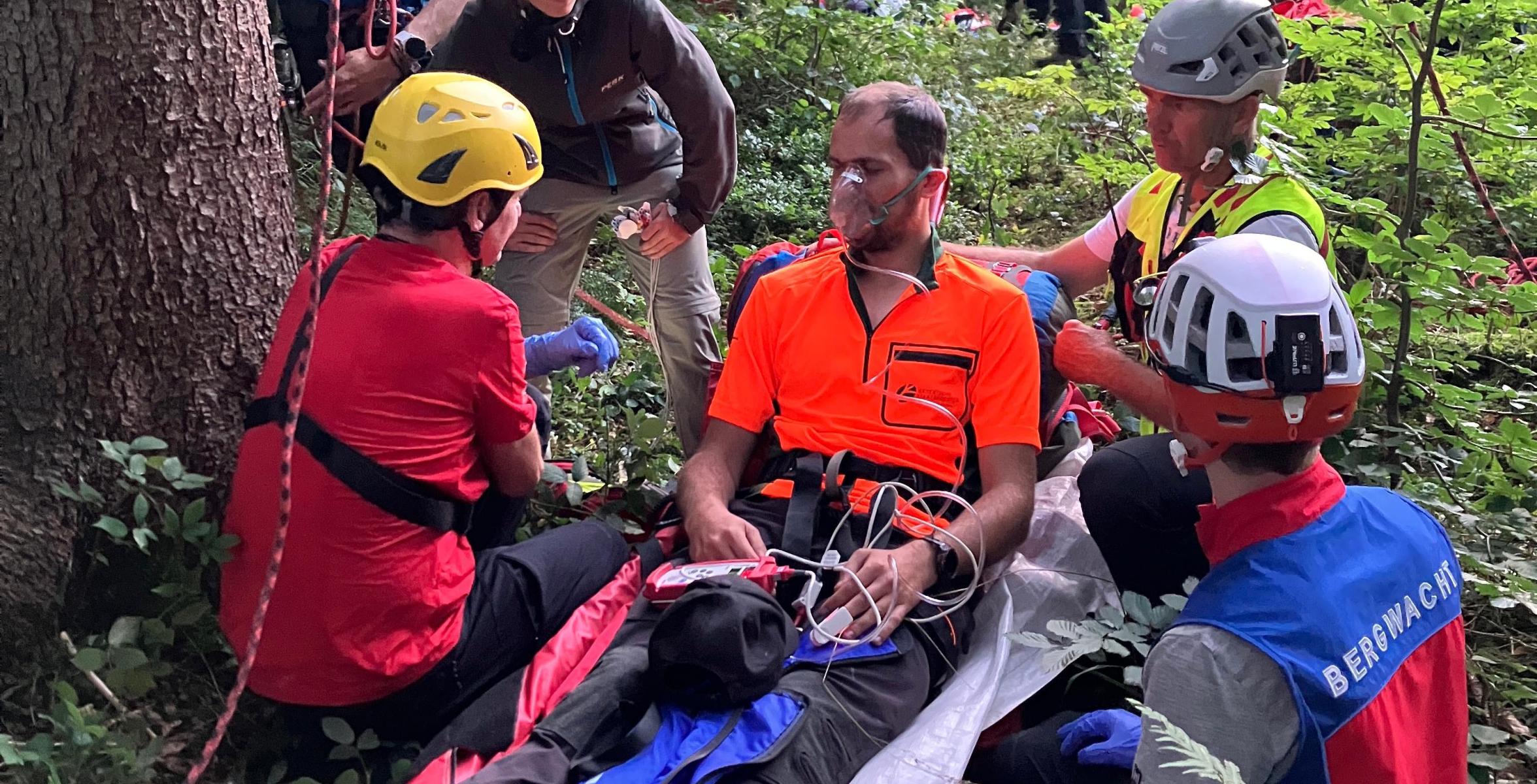 Rettungsübung: Förster auf einer Liege umgeben von Mitgliedern der Bergwacht