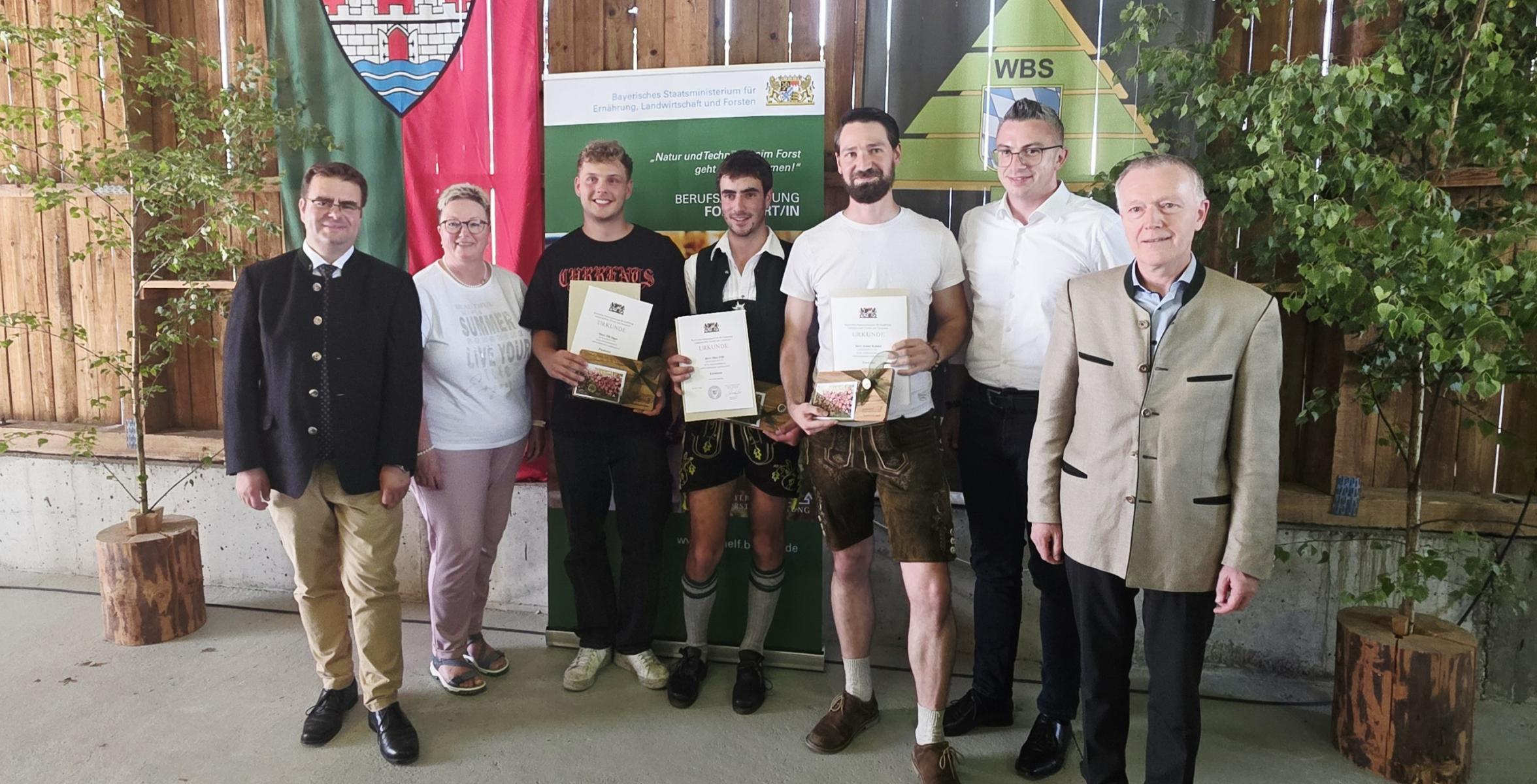 Die besten Forstwirte der Prüfung in einer Reihe mit Gratulanten