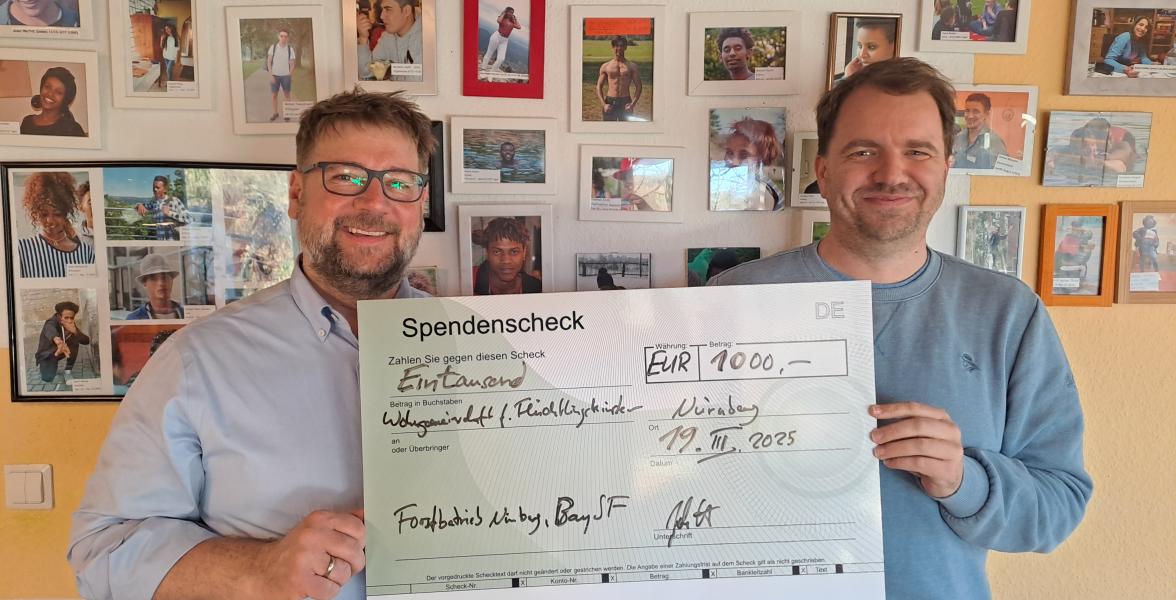 Forstbetriebsleiter und Leiter der Unterkunft präsentieren den Scheck