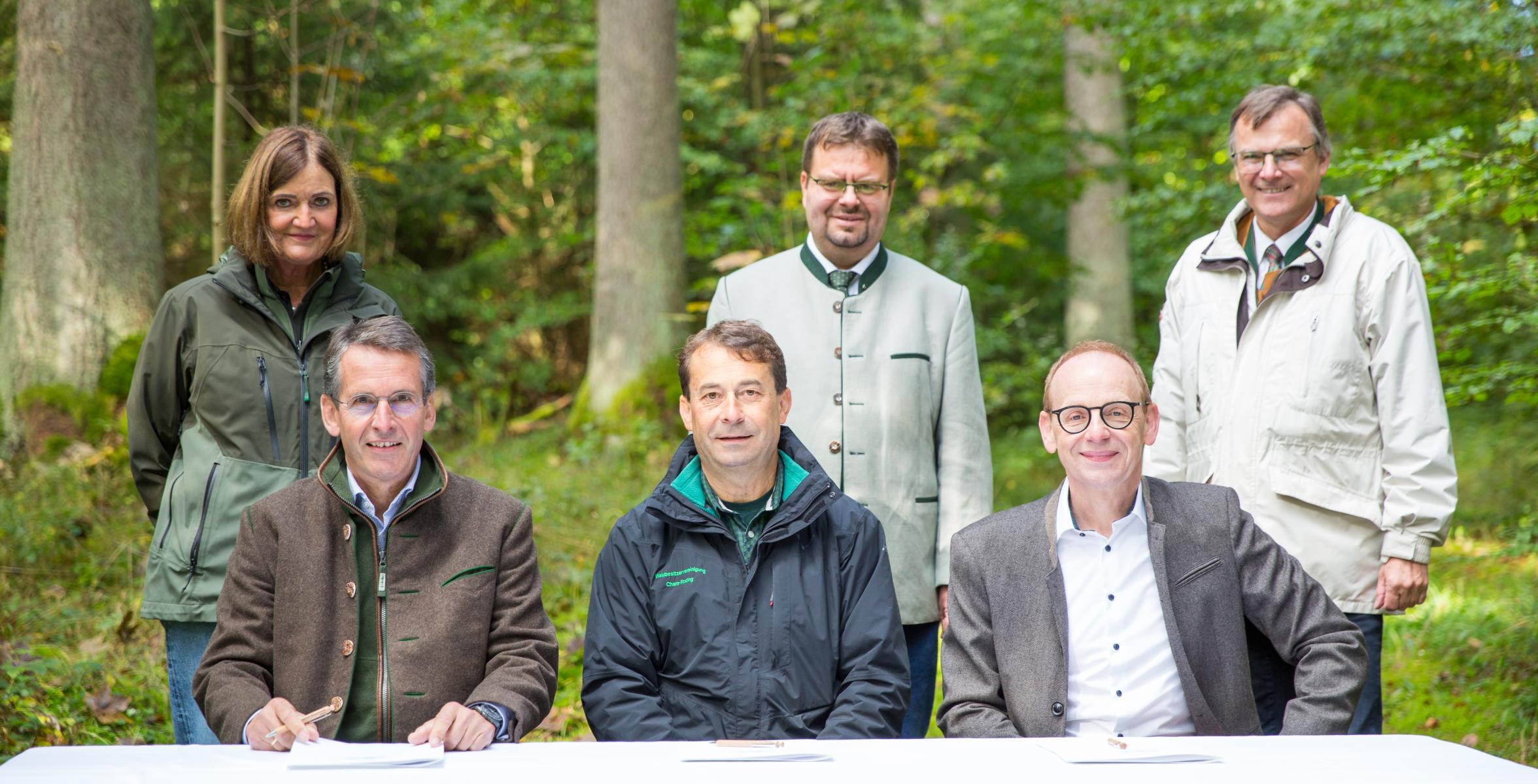 Personen unterzeichnen die Schutzwaldvereinbarung