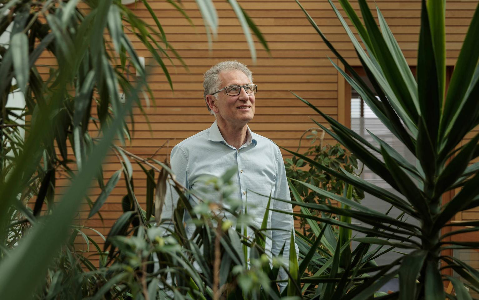 Förster steht vor Pflanzen in Bürogebäude