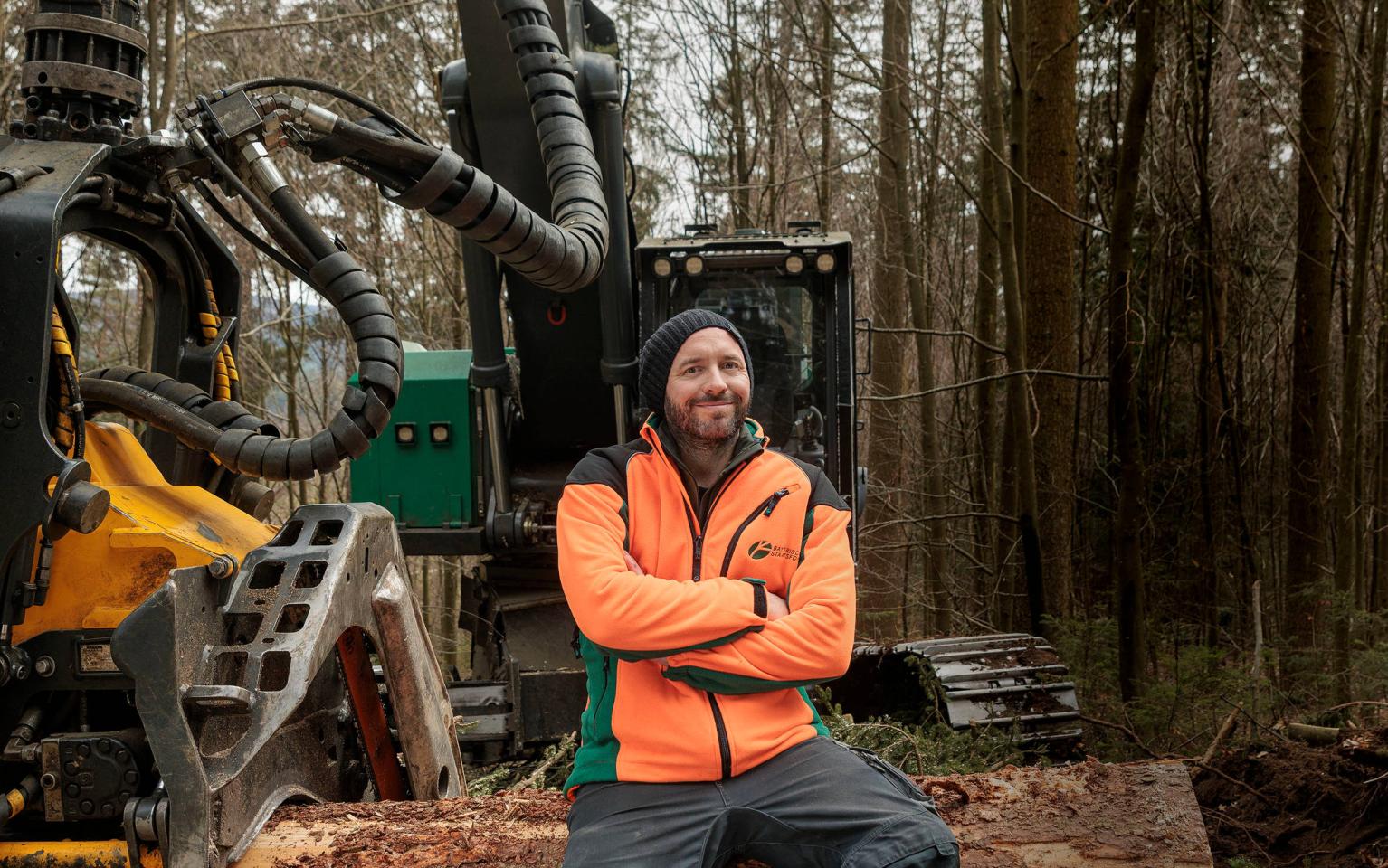 Forsttechniker sitzt auf Harvester im Wald
