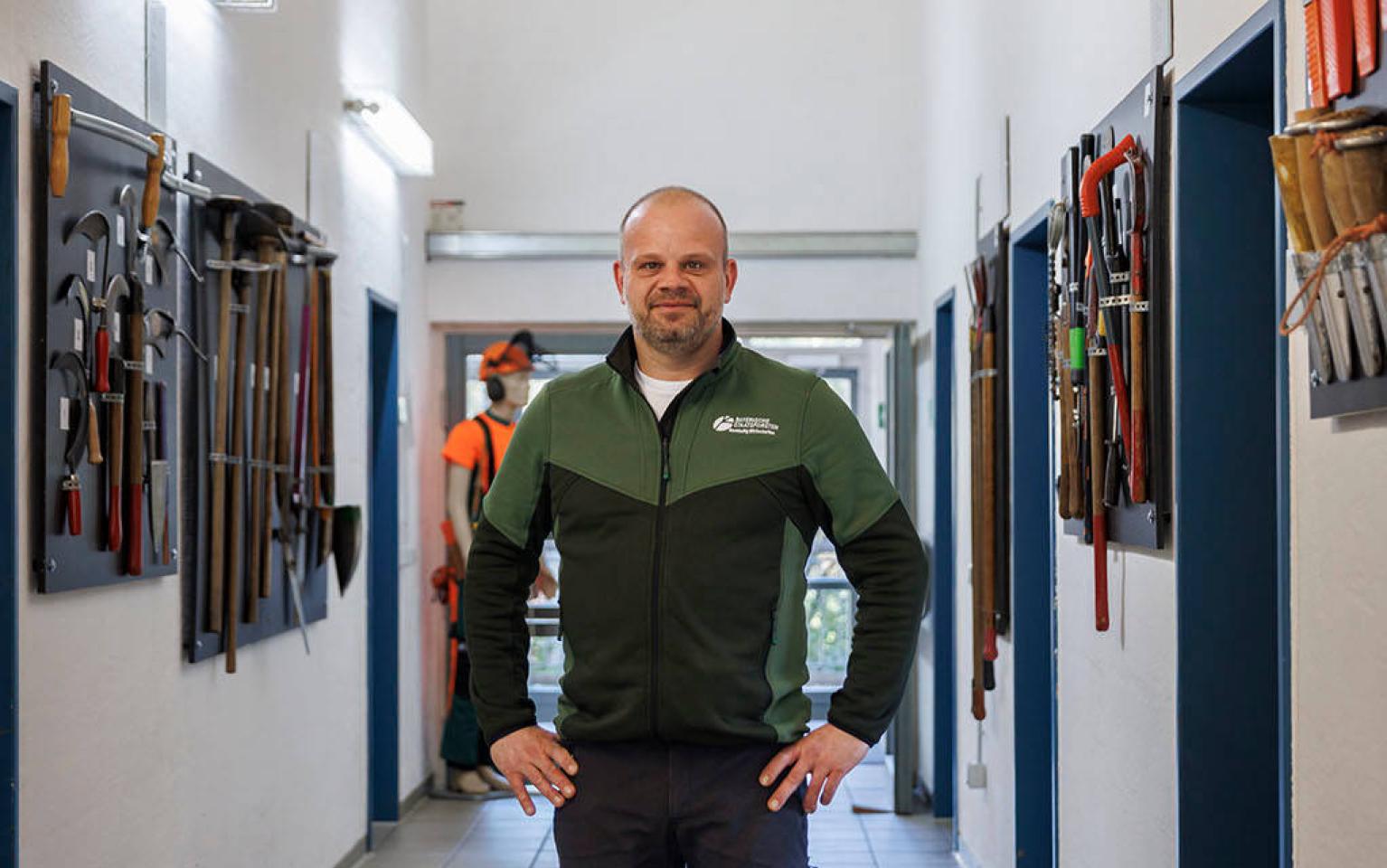 Forstwirtschaftsmeister Ausbilder steht in Ausbildungshalle für Forstwirte